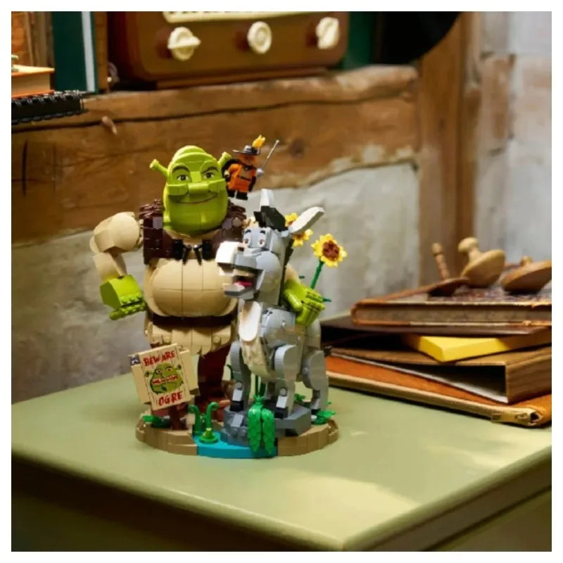 Brick build figurines on round base: green ogre with donkey beside, holding flowers
