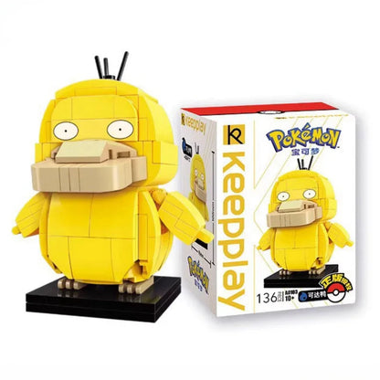 Psyduck brick building figure with a wide bill on a black base beside its box