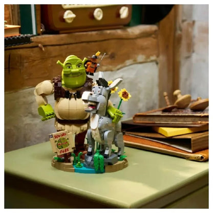 Brick build figurines on round base: green ogre with donkey beside, holding flowers