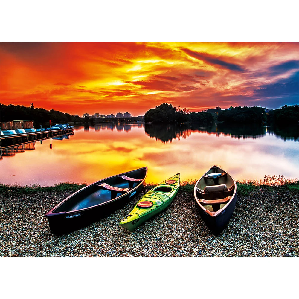 Three kayaks on a pebbled shore beside a lake at sunset, shown as the puzzle image