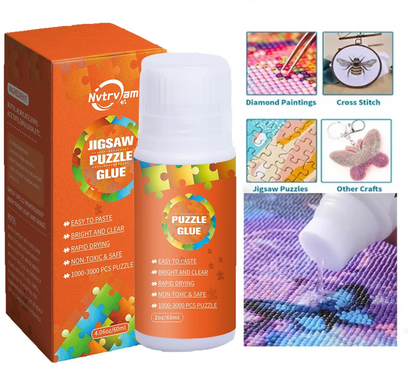 Glue bottle with orange label next to cardboard jigsaw puzzle glue box