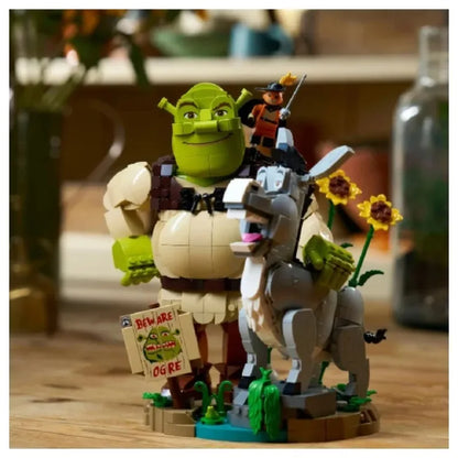 Brick build figurines: green ogre and white donkey with small rider, holding flowers