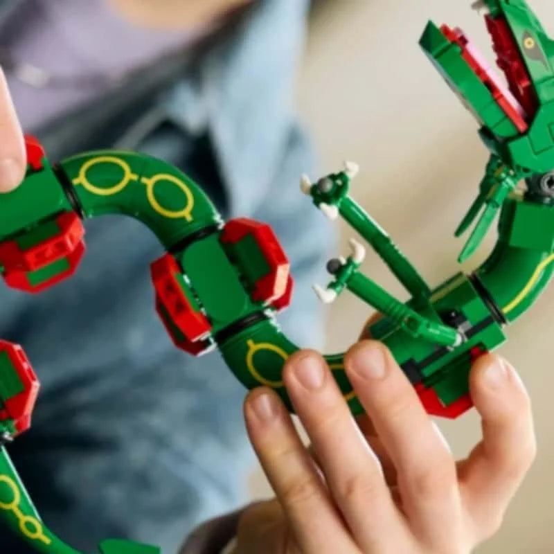 Close-up of hands holding green dragon sections with red armor and yellow trim details
