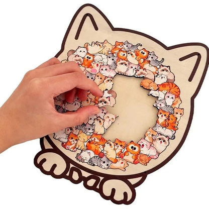 Cat-shaped puzzle with cartoon cat faces, hand placing a piece.