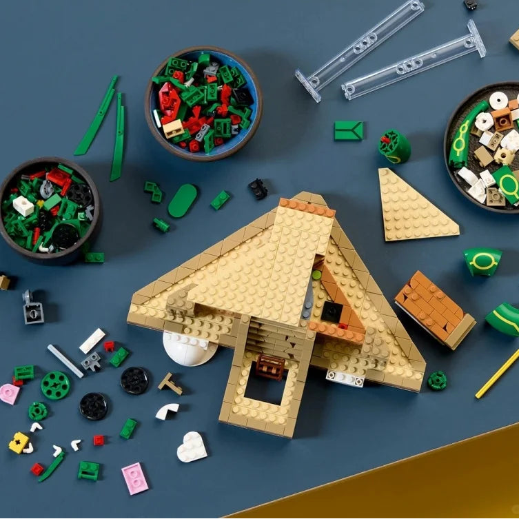 Flat-lay of build parts: tan model structure, green-red pieces, and white cloud elements