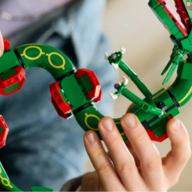Close-up of green dragon build pieces with red armor, yellow eye rings, and white joints